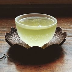 a glass filled with liquid sitting on top of a wooden table