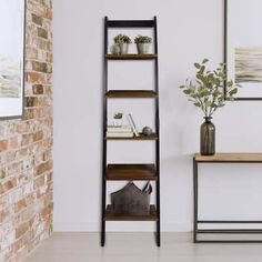 an empty room with a wooden shelf and potted plants on the table next to it