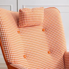 an orange and white checkered chair with buttons on the armrests is shown