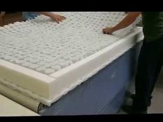 two people working on a mattress in a factory