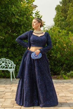 Adorned with intricate self-sequins, this deep blue masterpiece is sure to dazzle in the Adhara Lehenga. The look is completed with a full-sleeve blouse and a net dupatta that has been embellished with sparkling details. Pure luxury awaits in the Adhara Lehenga, an incredible work of art in a deep blue hue with intricate self-sequins that will leave you mesmerized. Team it up with an intricately designed full-sleeve blouse paired with a net dupatta embellished with sparkly details for the fashio Blue Lehenga Full Sleeve, Full Sleeves Blouse Design For Lehenga, Lehenga Designs Full Sleeves, Midnight Blue Lehenga, Full Sleeves Blouse Design For Lengha, Blouse Designs Full Hands, Long Sleeve Choli With Sheer Dupatta For Navratri, Elegant Blue Lehenga With Sequins, Lengha Blouse Designs Full Sleeves