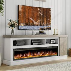 an entertainment center with a fireplace in the middle and pictures on the wall above it