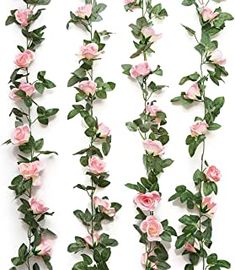 pink flowers are growing on the side of a white wall with green leaves and stems