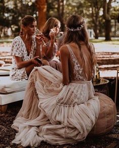 three women sitting on the ground in dresses