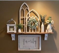 a shelf that has some plants on top of it with a family sign above it