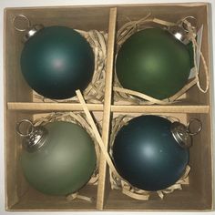 four green and blue ornaments in a box