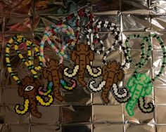 several beaded monkey necklaces are displayed on a shiny surface with plastic wrappers