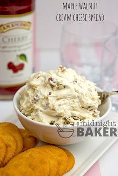 a white bowl filled with cream cheese spread next to crackers and a bottle of maple walnut cream cheese spread