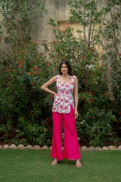 Elevate your ethnic style with our Pink Flower Printed Short Kurta Set. This two-piece ensemble features a sleeveless kurta adorned with delicate floral prints, exuding elegance and charm. Paired with trendy bell-bottom pants, crafted from a blend of georgette and cotton, this outfit offers both comfort and sophistication. Perfect for weddings or festive occasions, it's a must-have addition to your wardrobe. Flaunt your style effortlessly with this versatile ensemble! Item - Kurta with Bell Bott Short Kurta And Pants Women, Short Kurti And Pants Outfit, Short Kurti With Bell Bottoms, Short Kurta With Pants Women, Traditional Sleeveless Salwar Kameez For Reception, Festive Sleeveless Pant Set For Party, Sleeveless Sharara For Navratri Party, Sleeveless Party Sharara For Navratri, Bollywood Style Sleeveless Dress For Reception