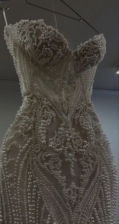 a dress made out of beads hanging from a clothes line