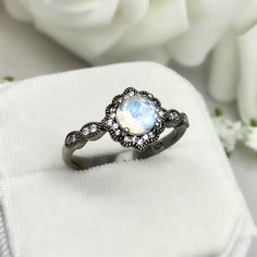 This beautiful ring is made from genuine 925 sterling silver with Black Rhodium plating. Ring details- -The Main stone is a round cut 6.5mm Natural Rainbow Moonstone Stone -Side stones are round 1.1mm simulated diamonds -Ring is casted in solid 925 sterling silver with Black Rhodium plating ( Rose Gold, yellow gold and White rhodium plated also available, please check the drop down menu for more options) -The Total face height of the ring measures 9mms and the band width measures 2mms -Each ring Celestial Round Moonstone Ring, Ethereal Round Moonstone Ring, Bohemian White Round Moonstone Ring, Sterling Silver Moonstone Halo Ring Gift, Bohemian Multi-stone Round Moonstone Ring, Rainbow Topaz, Engagement Ring Photos, Moonstone Ring Sterling Silver, Simulated Diamond Rings