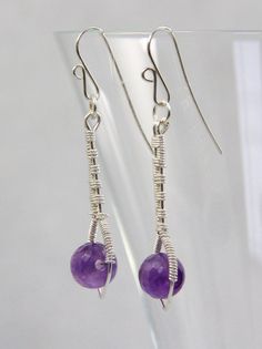 Faceted Amethyst beads (6mm) are encased in an inverted sterling silver wire teardrop.  The drop is at the end of a silver stem, all of which has been carefully woven together, in an intricate weave pattern, with sterling silver wire.  The ear wires are handcrafted of 22 gauge sterling silver wire. The total length of the earring is 1 3/4 inches (4.4 cm) Please see the 5th photo for an indication of size/scale.Please feel free to ask questions and thank you for visiting!!listing/263081997/red-ga Wire Wrapped Amethyst Drop Earrings, Silver Amethyst Wire Wrapped Earrings, Sterling Silver Jewelry With Round Birthstone Beads, Amethyst Birthstone Dangle Jewelry, Purple Gemstone Bead Dangle Earrings, Sterling Silver Gemstone Beads Earrings, Gift, Purple Gemstone Beads Dangle Earrings, Silver Earrings With Gemstone Round Beads, Silver Earrings With Gemstone Beads