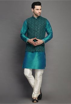 Art Silk Kurta in Teal Blue This Readymade attire is Enhanced with Buttons, Resham and Sequins Work. Crafted in Chinese Collar Neck and Full Sleeve Available with an Art Silk Churidar in Off White and a Faux Georgette Nehru Jacket in Dark Green Do note: Footwear shown in the image is for presentation purposes only. Half to one inch may vary in measurement. (Slight variation in actual color vs. image is possible) Traditional Blue Nehru Jacket With Intricate Embroidery, Traditional Blue Kurta With Embroidered Sleeves, Traditional Blue Sets With Embroidered Sleeves, Green Floral Embroidered Nehru Jacket For Eid, Traditional Blue Nehru Jacket With Chikankari Embroidery, Blue Nehru Jacket With Chikankari Embroidery For Festive Occasions, Festive Blue Nehru Jacket With Chikankari Embroidery, Blue Floral Embroidered Bandhgala For Designer Wear, Blue Nehru Jacket With Intricate Embroidery For Festive Occasions