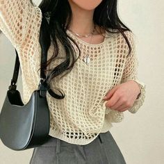 a woman with long black hair holding a gray purse