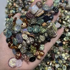 a person's hand holding a bunch of glass bead pieces in their palm