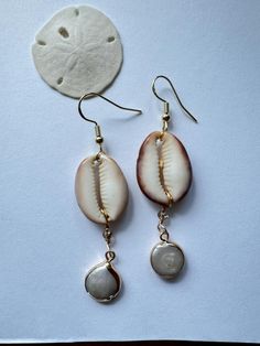 Bottom of cowry shell, mother of pearl gold detailed dangled earrings, handmade and  shells found on island of Kauai, Hawaii. Handmade Gold Jewelry For Vacation, Unique Gold Jewelry For Vacation, Shell Jewelry With Pearl Charm For Vacation, Gold Shell Jewelry For Vacation, Mother Of Pearl Jewelry For Vacation, Beach Jewelry With Pearl Charm And Mother Of Pearl, White Shell Pearl Earrings For Beach, Gold Teardrop Jewelry For Beach, Vacation Shell Necklace With Mother Of Pearl