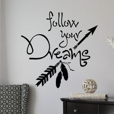 a wall decal that says follow your dreams with an arrow and feathers on it