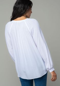 A classic bohemian button-front blouse in a soft and silky crepe. Silky crepe Relaxed fit Long voluminous sleeve Smocked elastic wrist cuff Split v-neckline Button front Bohemian blouse For the office and beyond, this classic button-front blouse is the go-to style of the season. Designed in a soft and silky crepe. Featuring voluminous long sleeves, smocked elastic wrist cuffs, and an ultra-relaxed fit. Model is 5'9, wearing a size S.Style: I-13877W-RPL Chic V-neck Smocked Top With Blouson Sleeves, Elegant V-neck Peasant Top For Fall, V-neck Smocked Top For Brunch, Billowy Long Sleeve Top With Smocked Cuffs, Spring V-neck Peasant Top With Blouson Sleeves, Bohemian V-neck Top With Smocked Back, Bohemian V-neck Tops With Smocked Back, Casual V-neck Puff Sleeve Top For Daywear, Casual Flowy V-neck Peasant Top