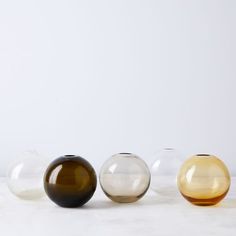 three glass vases sitting on top of a white counter