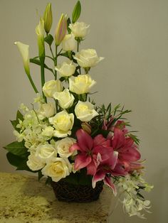 a basket filled with lots of flowers sitting on top of a counter next to a wall