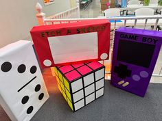 three different colored rubik cubes sitting next to each other on the floor in front of a railing