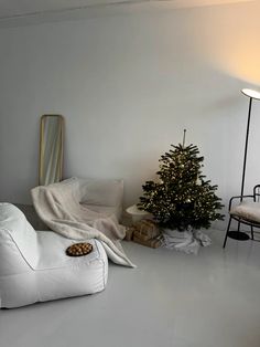 a white living room with a christmas tree in the corner