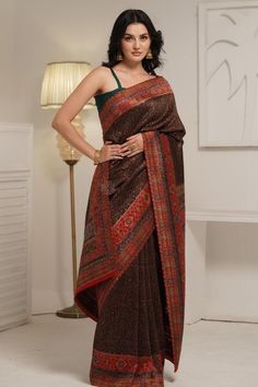 Black Kani Jamawar Saree in silk fabric is accentuated with Kani Jamawar weaving over the body in traditional patterns & flowers along the borders and pallu. Some zari woven into the patters adds a right amount of shine. The look is complete with a red saree blouse piece that has Kani weaving in booti pattern. The design inspiration for this Pashmina Silk saree is drawn from the heritage weaves of ancient Pashmina shawls from our history that dates back to the Mughal era.  Kani is an ancient and Elegant Jamawar Pre-draped Saree For Eid, Elegant Pre-draped Jamawar Saree With Pallu, Transitional Silk Pre-draped Saree With Printed Border, Festive Tussar Silk Pre-draped Saree With Printed Border, Traditional Festive Jamawar Pre-draped Saree, Elegant Pre-draped Saree With Printed Border For Designer Wear, Designer Tussar Silk Pre-draped Saree With Printed Border, Semi-stitched Traditional Wear With Printed Border, Traditional Silk Pre-draped Saree For Eid