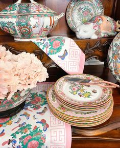 a table topped with plates and vases filled with flowers