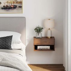 a bedroom with a bed, nightstand and pictures on the wall