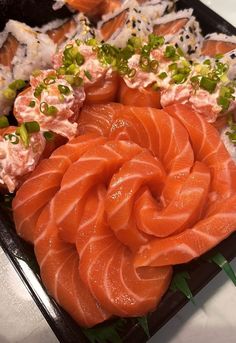 there are many different types of sushi on the trays, including salmon and shrimp