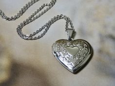 "This sweet silver heart locket necklace is a great keepsake necklace. It opens for your favorite two photographs. You will need to find a photo that fits and glue it into place. We do not place the photo in for you and at this time we do not engrave. Its the perfect gift for all ages I T E M * DETAIL: - PENDANT SIZE: Outside measurements 1 1/8\" x 1\", Inside measurement 7/8\" x 3/4\" - CHAIN LENGTH: 18\" Silver Link Chain over stainless steel C A R E * T I P S: We don't want your special momen Heart Locket Necklace Silver, Keepsake Necklace, Silver Heart Locket, Silver Locket Necklace, Silver Link Chain, Soft Boy, Heart Locket Necklace, Necklace Ideas, Dope Jewelry