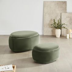 two green ottomans sitting on top of a white floor