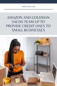 a woman is looking at her credit card while sitting in front of boxes on the table