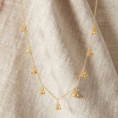 A really pretty handmade jangly gold necklace with Sterling Silver and 18 carat gold. Handmade ball charms clustered and dangling in trios, and hanging all along the chain.  Great for adding an extra layer with a more textured look, to your existing chains. Feminine and elegant to wear on its own, and for anyone who loves a flattering, understated and minimalist charm style necklace. Handmade using 18K Gold and Sterling Silver, I never use inferior metals in any of my designs. This necklace meas Bohemian Gold Charm Necklace With Clavicle Chain, Dainty Gold Charm Necklace With Dangling Charms, Delicate Gold Charm Necklaces In Brass, Dainty Necklace With Dangling Pendant Charms, Dainty Pendant Necklace With Dangling Charms, Dainty 14k Gold-filled Necklace With Dangling Charms, Delicate Handmade Gold Charm Necklaces, Gold Plated Necklaces With Dangling Charms, Tiny Gold-plated Charm Necklaces