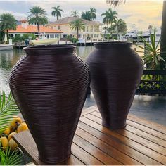 two large vases sitting on top of a wooden deck