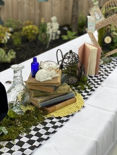 a table topped with books and vases filled with plants