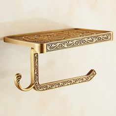 an ornately designed brass towel rack hangs on the wall