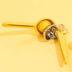 a yellow pair of scissors and a ball on a yellow surface with other objects around it