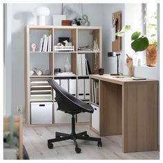 an office chair sitting in front of a desk with bookshelves and drawers on it