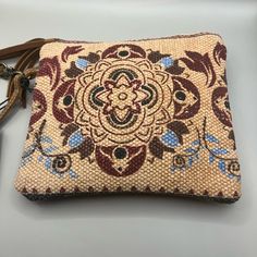 This Myra Bag Women's Canvas Purse In The "Lurantis" Pouch Style Is A Versatile And Stylish Addition To Any Outfit. With A Small Size Of 8.5" X 7.5", It Can Be Used As A Wristlet For Casual Occasions. The Bag Features A Beautiful Floral Pattern And Is Made Of Canvas And Leather Materials, With Gold Hardware Accents And A Brushed Finish. The Wrist Strap Is Brown In Color And Measures 5 Inches In Drop Length. The Bag Has A Zip Closure And Is Lined With Canvas And Leather Materials In A Brown Color Natural Pouch Shoulder Bag For On-the-go, Bohemian Beige Pouch Bag, Cream Pouch Bag With Leather Handles, Brown Clutch With Removable Pouch For On-the-go, Leather Handle Pouch Clutch For Travel, Bohemian Rectangular Cosmetic Bag For Daily Use, Bohemian Cosmetic Bag For Daily Use, Brown Zipper Pouch Bag For On-the-go, Everyday Leather Handle Pouch Clutch