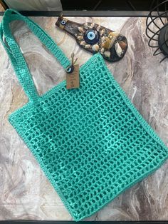 a green crocheted bag sitting on top of a table