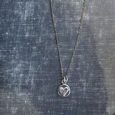 "This nickel-sized solid sterling silver heart pendant is a great way to bring you or a loved-one a virtual hug. The perfect gift. May request up to 3 initials stamped on the back (request in notes). Cast from recycled sterling silver scrap metal. Available in 16\" & 18\" length (make your selection at check out) on an oxidized (antiqued) flat figaro style chain." Silver Necklace With Initial Pendant And Heart Charm, Nickel-free Heart Pendant Necklace For Everyday, Sterling Silver Heart Necklace With Round Pendant, Silver Heart Charm Necklace For Mother's Day, Silver Hand Stamped Heart Necklace For Anniversary, Silver Heart Necklace With Round Pendant For Keepsake, Silver Heart Necklace With Round Pendant For Mother's Day, Silver Open Heart Keepsake Charm Necklace, Silver Open Heart Charm Necklace For Keepsake