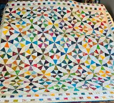 a colorful quilt is displayed on a table