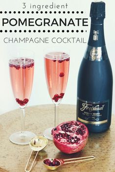 two glasses filled with pink wine and pomegranate next to a bottle of champagne