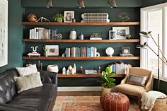 a living room filled with furniture and bookshelves next to a wall mounted shelf