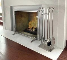 a fireplace with a fire in it and some metal poles on the side of it