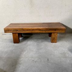 a wooden bench sitting on top of a cement floor