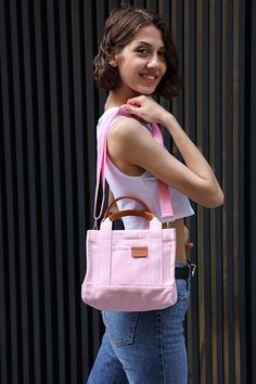 EXPRESS FAST SHIPPING FOR CHRISTMAS!  Check out our Pink Mini Canvas Tote--a practical and stylish sidekick for your everyday hustle. Boasting a single roomy space, a sturdy leather handle, and handy pockets inside and out, this bag is all about simplicity with a touch of smart design. The soft lining and easy snap closure keep things fuss-free. Plus, switch it up with the removable, adjustable shoulder strap--carry it your way, whether by hand, on your shoulder, or slung cross-body. Meet your new favorite, effortlessly cool companion! Details: Single compartment Leather handle Inner and outer pockets Lined Fabric Snap closure Removable and adjustable shoulder strap Size: Width: 24 cm (9,4 inches) Length: 20 cm (7,8 inches) Depth: 12 cm (4,7 inches) Strap: 110 cm (43 inches) You can visit Trendy Canvas Mobile Phone Bag, Canvas Satchel Shoulder Bag For Mobile Phone, Pink Large Capacity Handheld Satchel, Pink Handheld Satchel With Large Capacity, Canvas Shoulder Bag With Double Handle For Mobile Phone, Crossbody Canvas Bag For Shopping, Pink Handheld Satchel For School, Small Canvas Bag For Shopping, Canvas Satchel With Mobile Phone Pocket