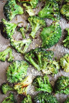 cooked broccoli florets with seasoning sprinkles on a baking sheet