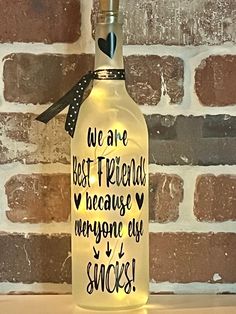 a bottle with some writing on it sitting in front of a brick wall that says, we are best friends